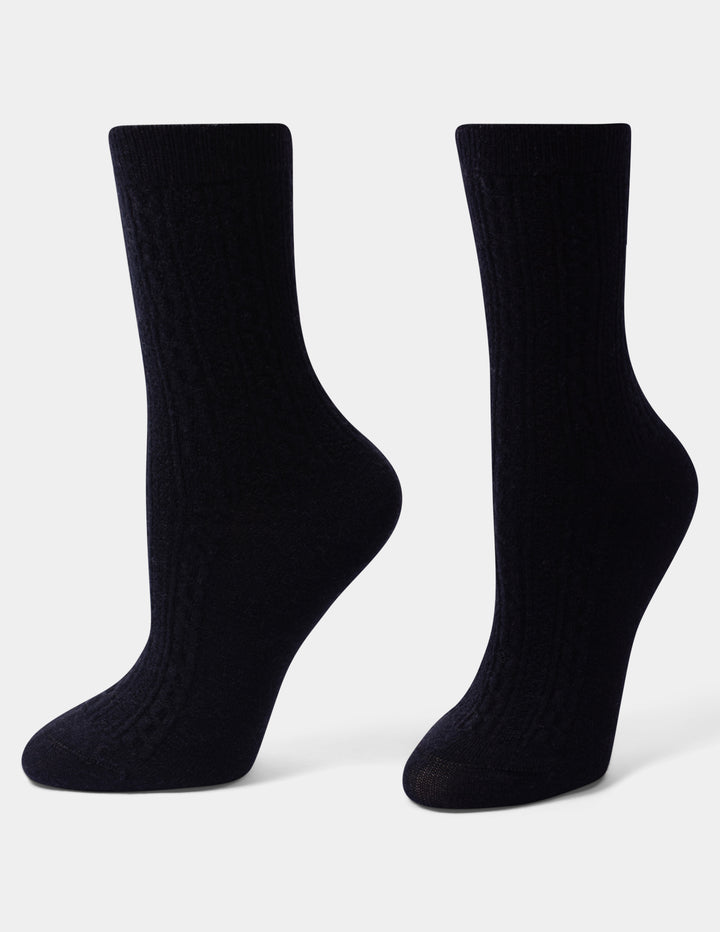 A pair of black crew socks with a ribbed texture, displayed on a light gray background.