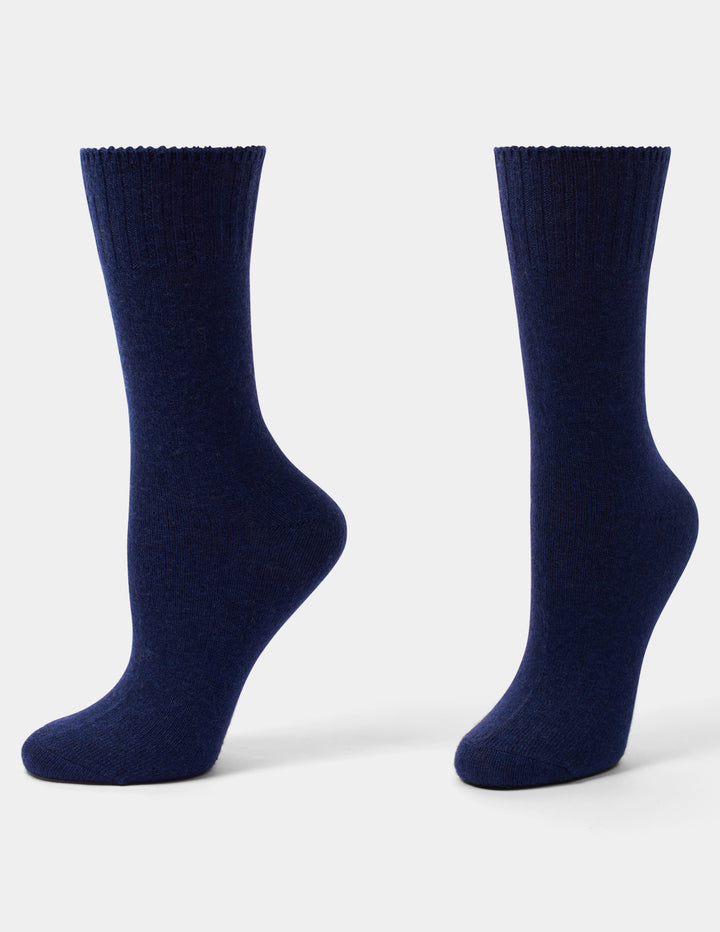 A pair of dark navy blue crew socks shown from the back, standing upright against a light gray studio background.