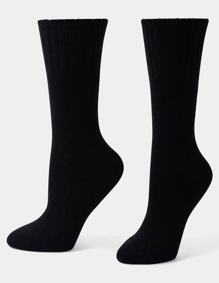 A pair of black crew-length socks displayed on invisible forms against a light gray background.