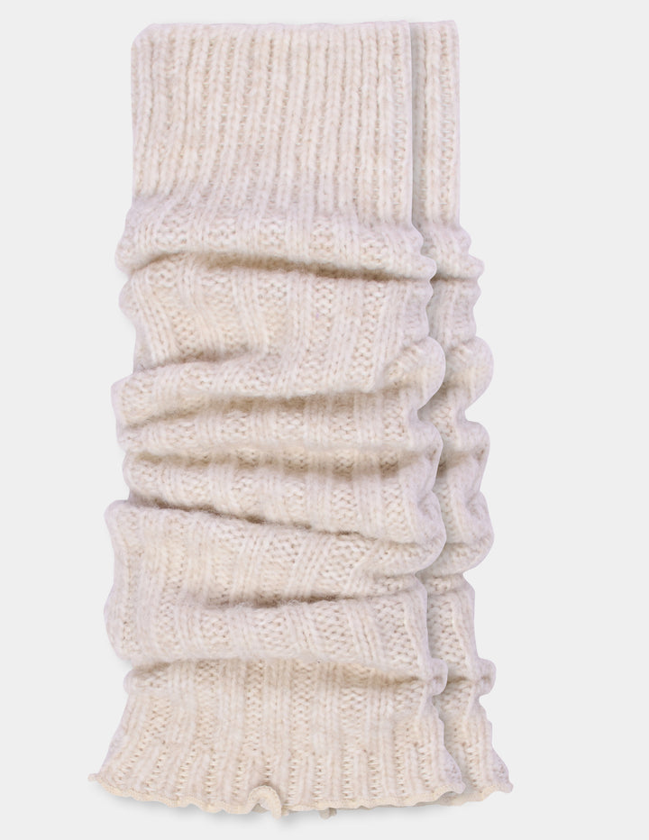 Ribbed light beige leg warmers laying flat, photographed against a light gray background.