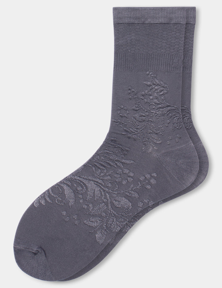 A pair of dark gray crew socks with an embossed floral pattern on the foot, displayed against a light gray background.