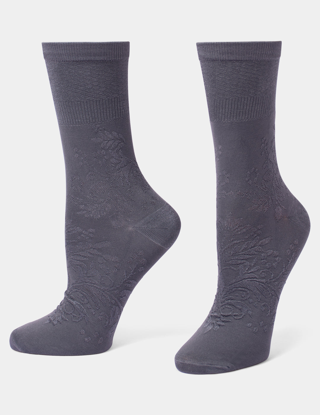 A pair of dark gray crew socks with a subtle tonal floral jacquard pattern, displayed on foot forms against a light gray background.