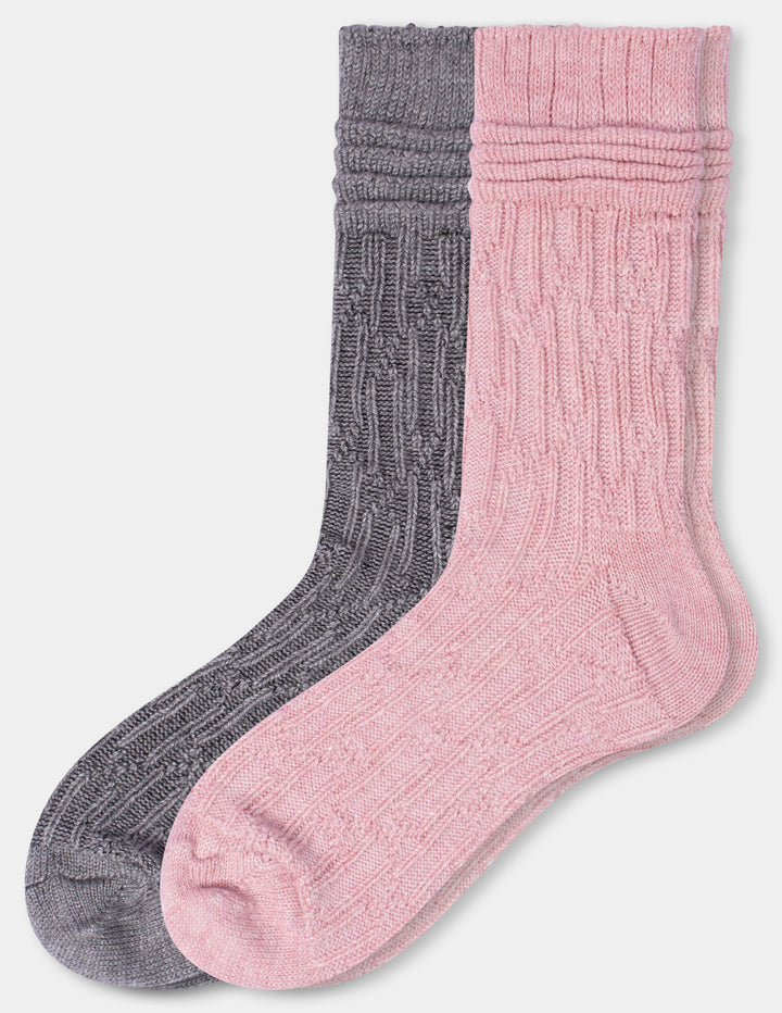 Two ribbed cable-knit crew socks, one in dark gray and one in light pink, displayed overlapping against a light gray background.