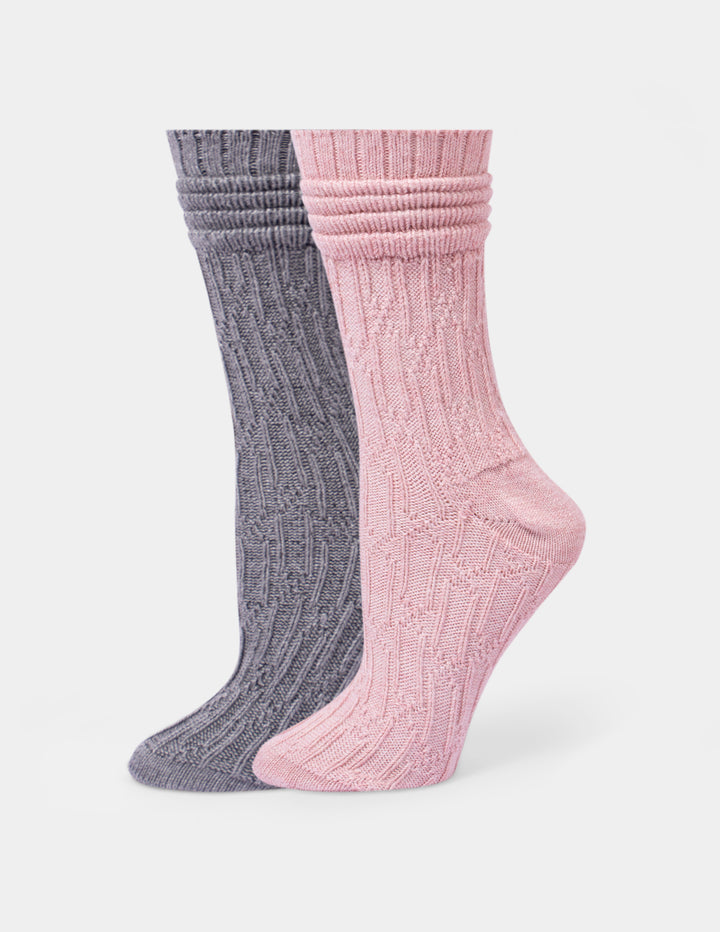 Two pair of ribbed crew socks shown on foot forms, with one sock in heather gray and the other in dusty pink, against a light gray background.