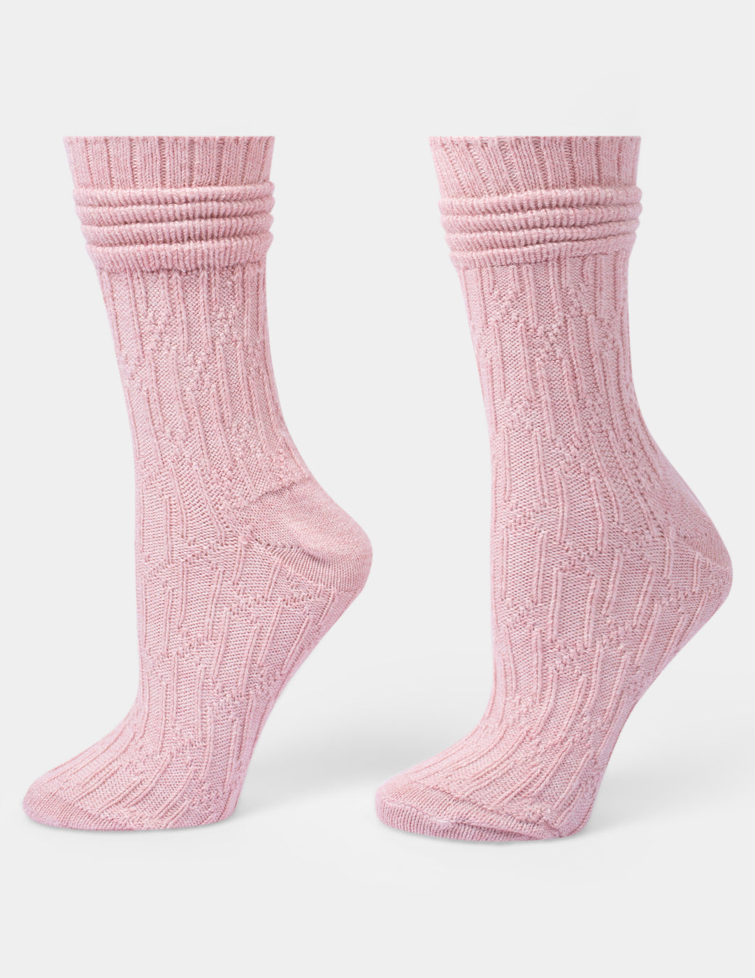 A pair of light pink ribbed knit crew socks shown on foot forms against a light gray background.