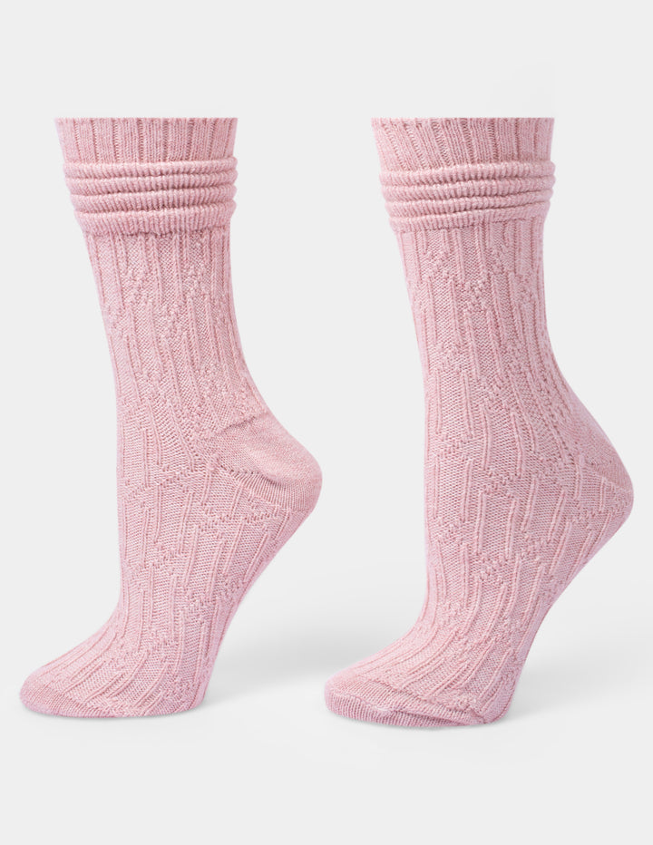 A pair of light pink ribbed knit crew socks shown on foot forms against a light gray background.