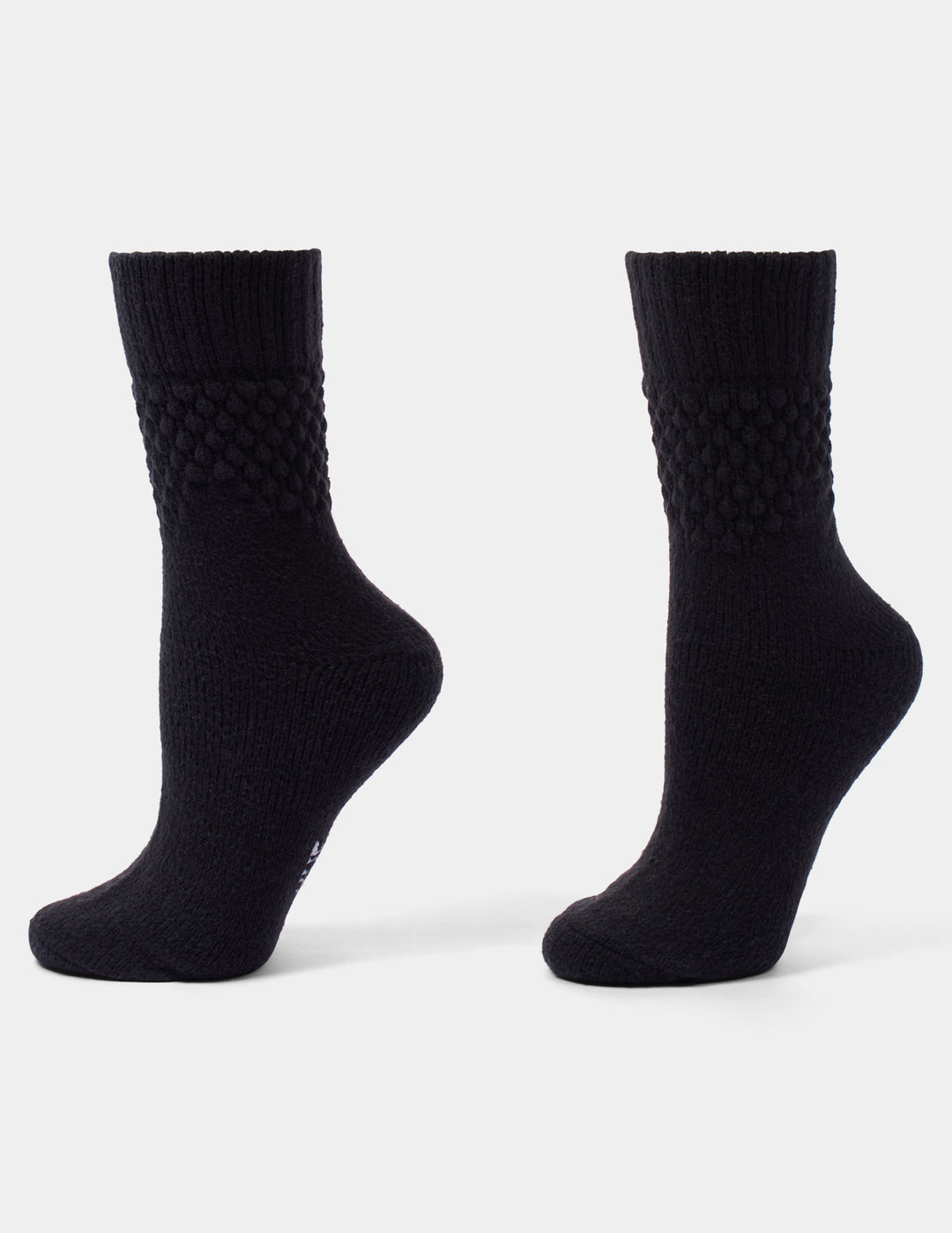 A pair of black crew socks with a textured, diamond-patterned ribbed cuff, shown from the side against a light gray background.