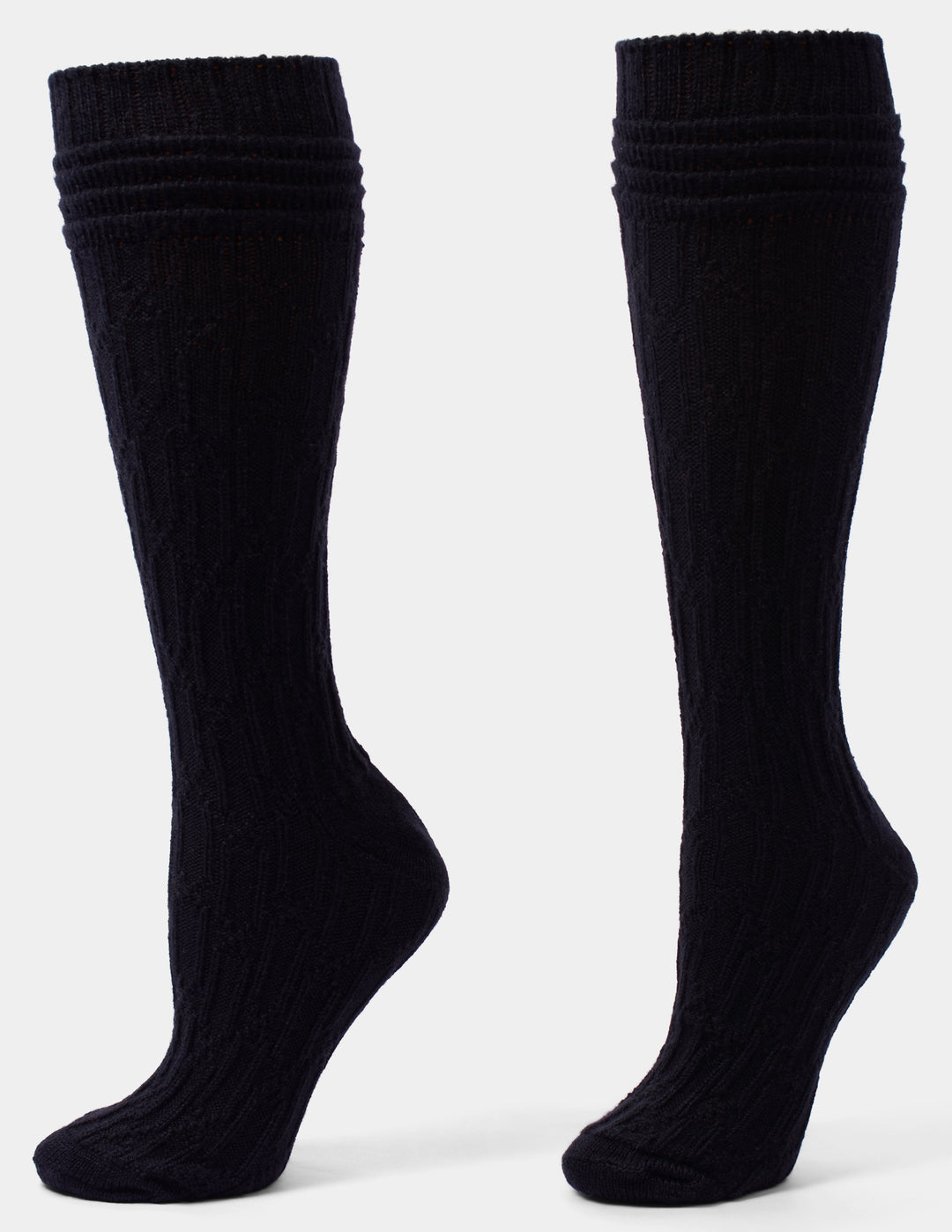 A pair of black cable knee socks against a light gray background. 