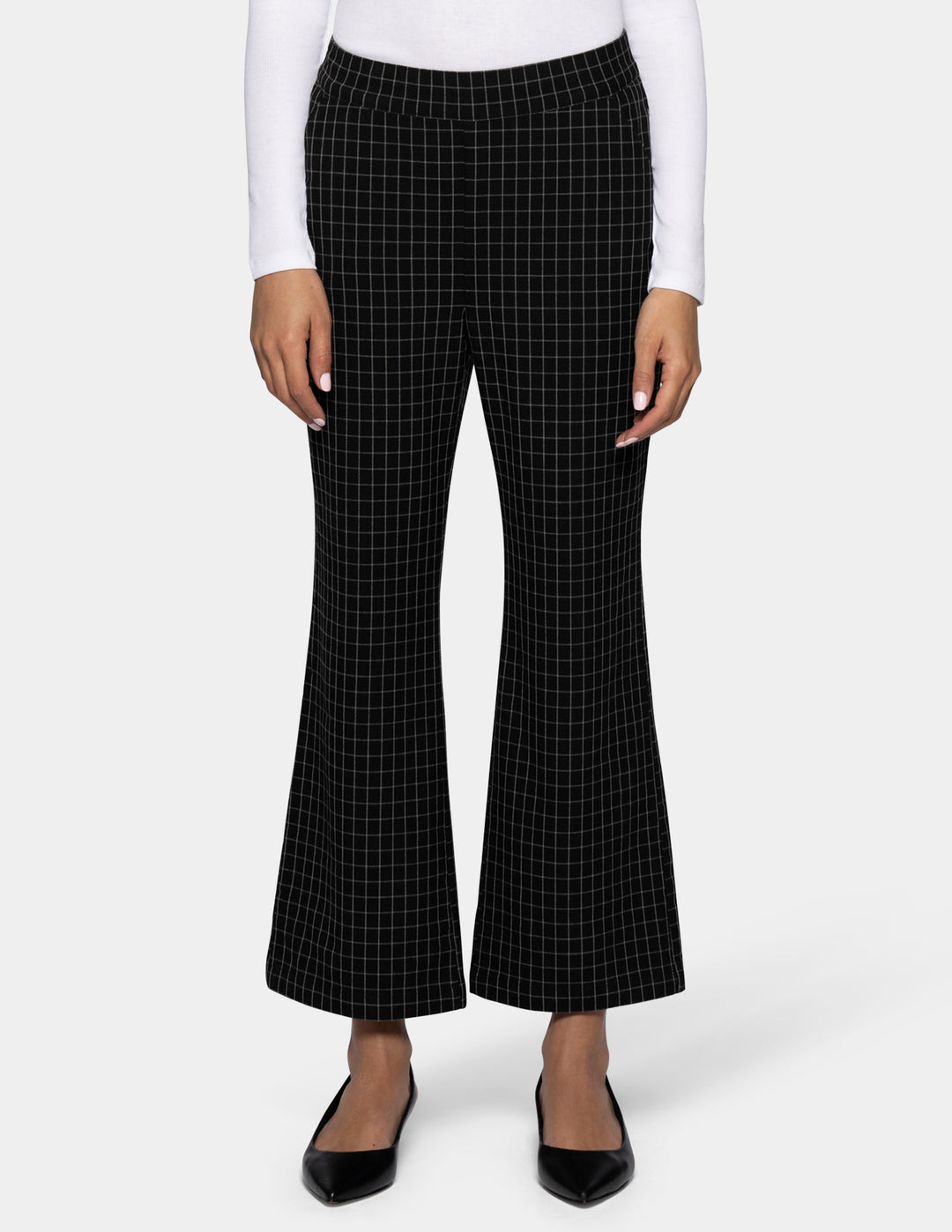 Black flare cropped pants with a white windowpane grid pattern, shown on a model wearing a white long-sleeve top and black flats against a light gray background.