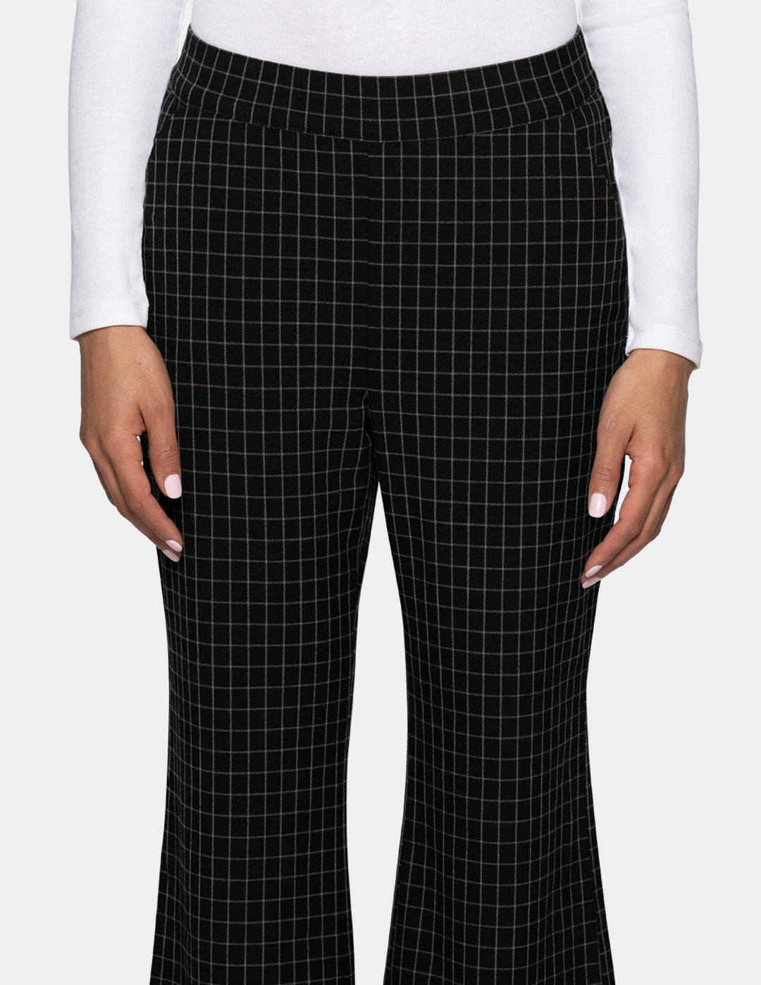 Black flare pants with a white windowpane grid pattern, shown on a model wearing a white long-sleeve top against a light gray background.
