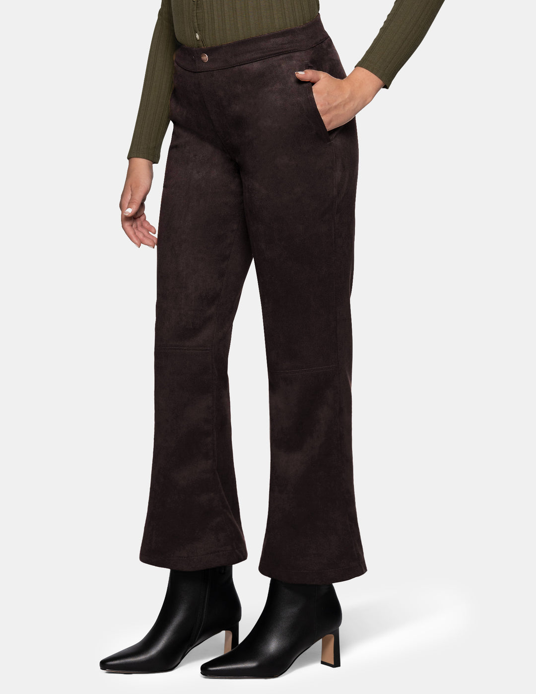 A sideview of a model wearing dark brown suede flare pants paired with a long sleeve olive top and black boots, photographed against a light grey background.