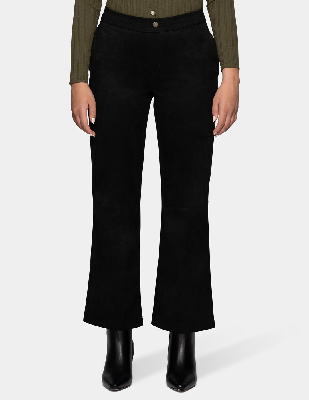 A model wearing black flare pants, an olive green long sleeve top, and black booties, photographed against a light grey background.