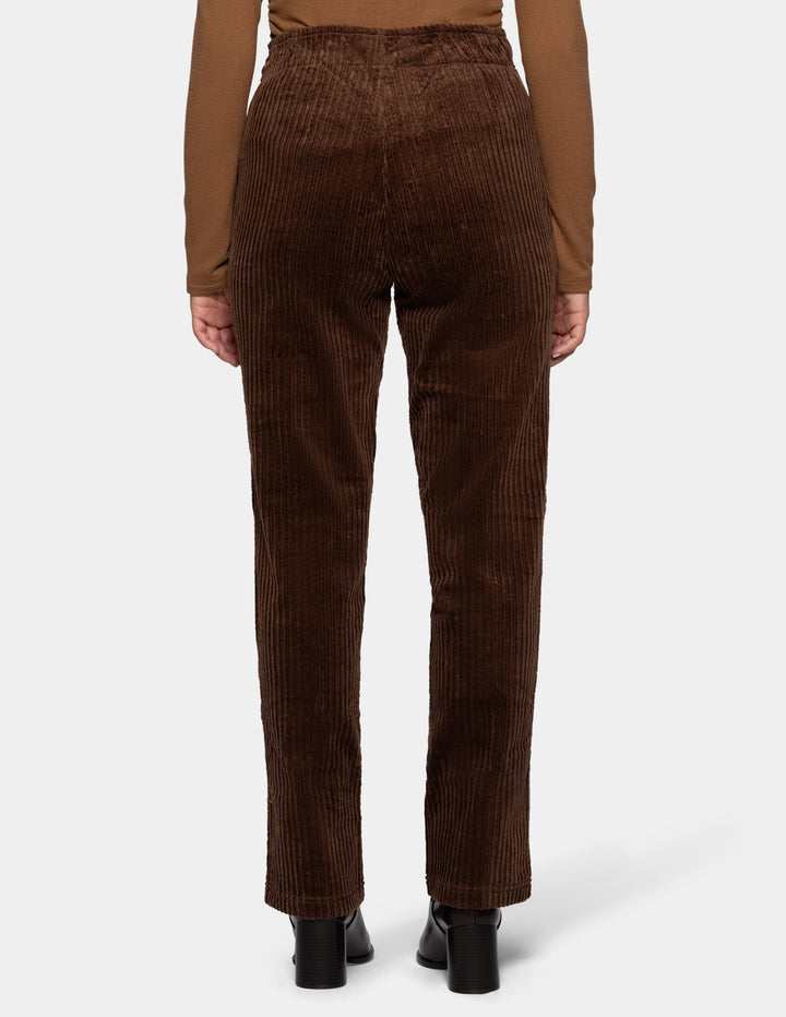 A backside view of a model wearing brown straight leg corduroy pants paired with a lighter brown long sleeve top and black boots, photographed against a light gray background.