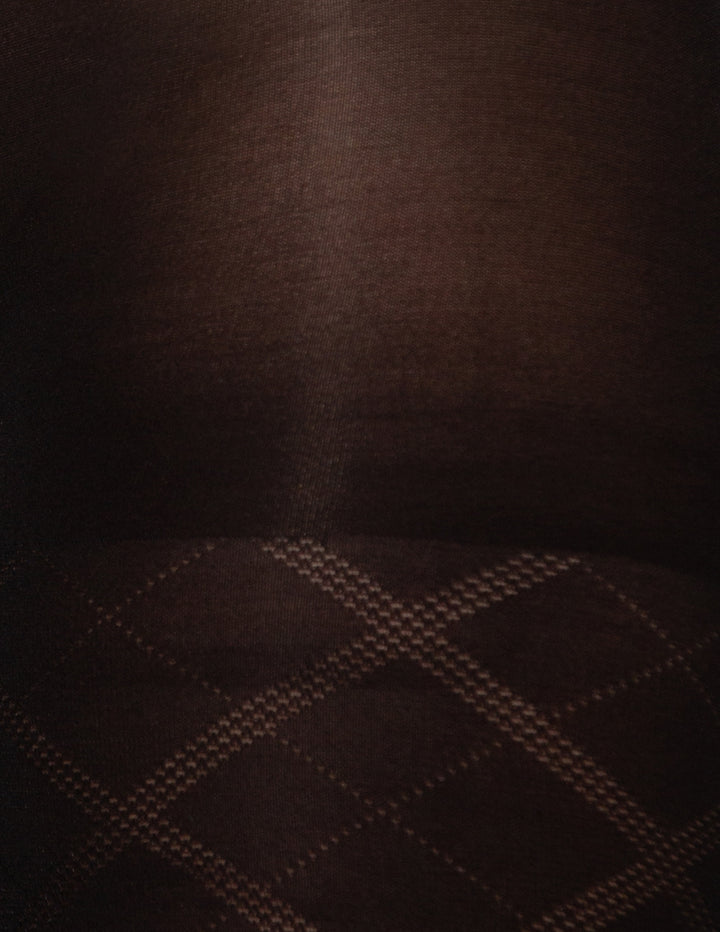 Close-up of a black textured fabric with a subtle diamond plaid pattern visible along the bottom edge.