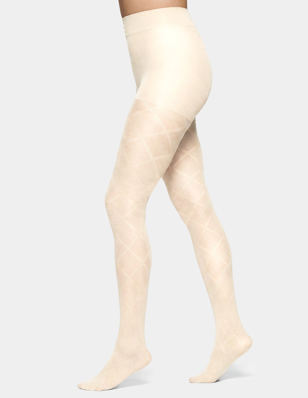 A model's legs wearing a pair of high-waisted, sheer tights with a subtle diamond argyle pattern in a light cream color, shown against a solid light gray background.