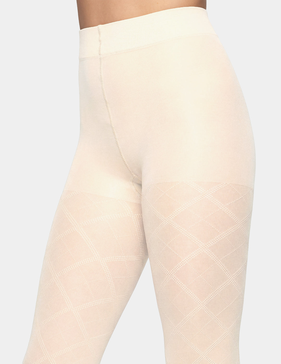Close-up of a model wearing high-waisted tights in a light beige shade with a subtle diamond pattern on the thighs, set against a plain light gray background.