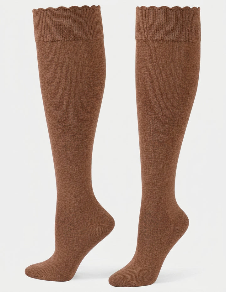 A pair of knee-high socks in a warm brown color against a light gray background.