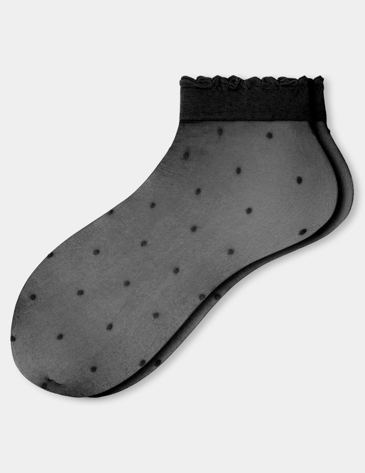 A pair of black ankle socks with a delicate ruffled trim at the top and small black polka dots, shown against a light gray background.