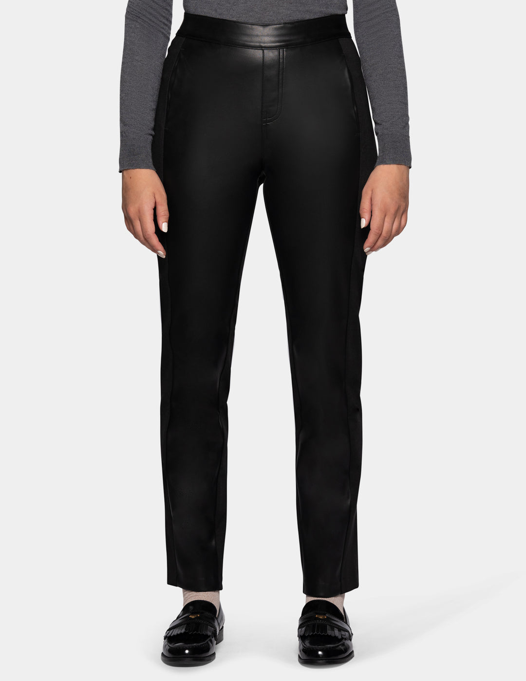 A model wearing black faux leather pants, a long sleeve grey top, and black loafers.