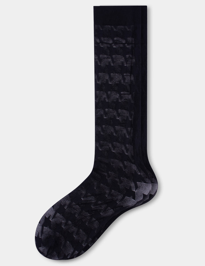 A pair of black knee high socks with a houndstooth pattern, shown against a light gray background.