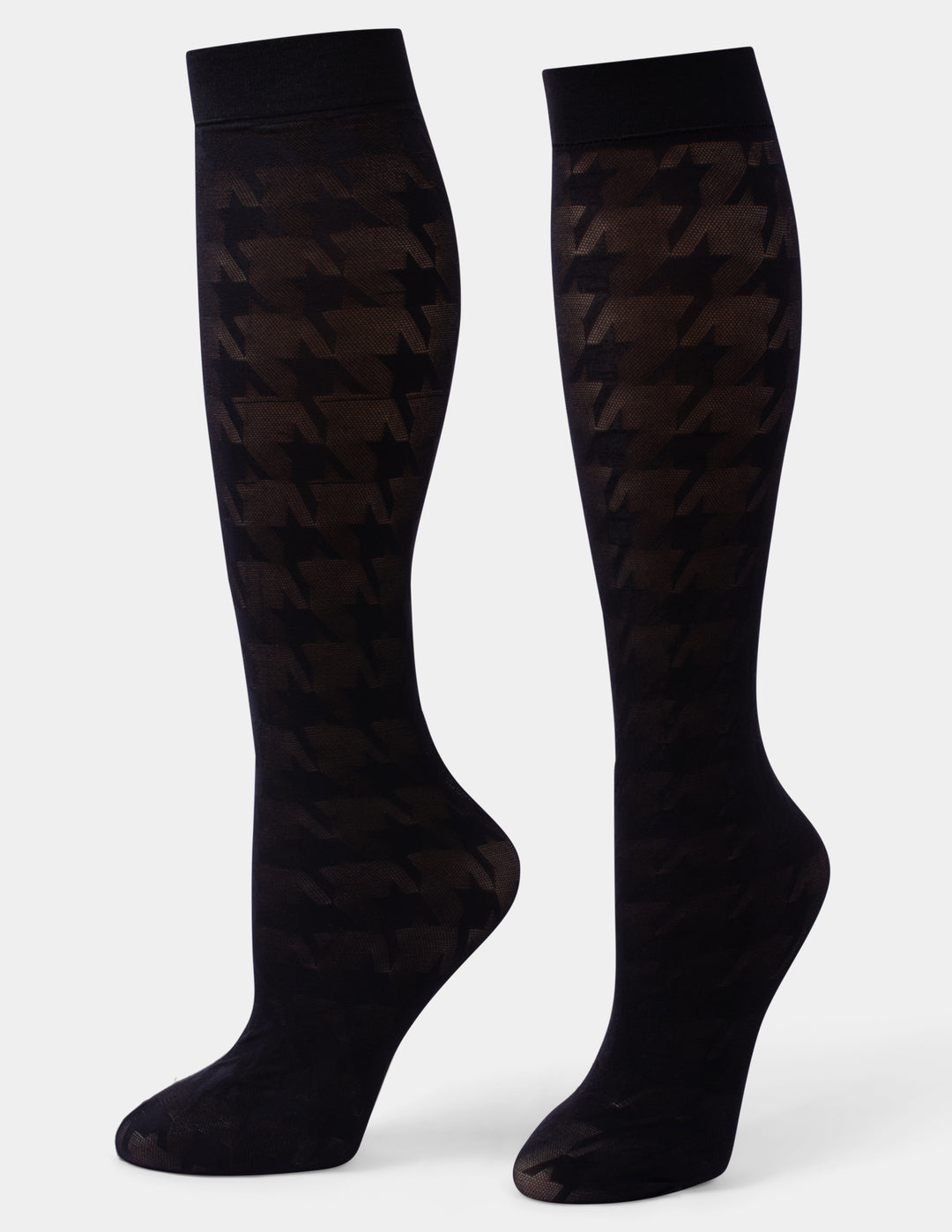 A pair of black knee-high socks with a subtle houndstooth pattern, displayed on foot forms against a light gray background.