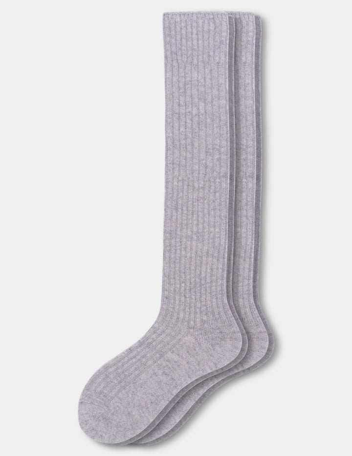 A pair of light gray ribbed knee-high socks stacked together on a light gray background.