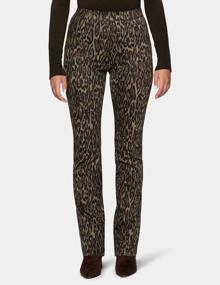 A model wearing olive leopard print leggings and a long sleeve dark color top, paired with dark brown suede boots against a light gray background.