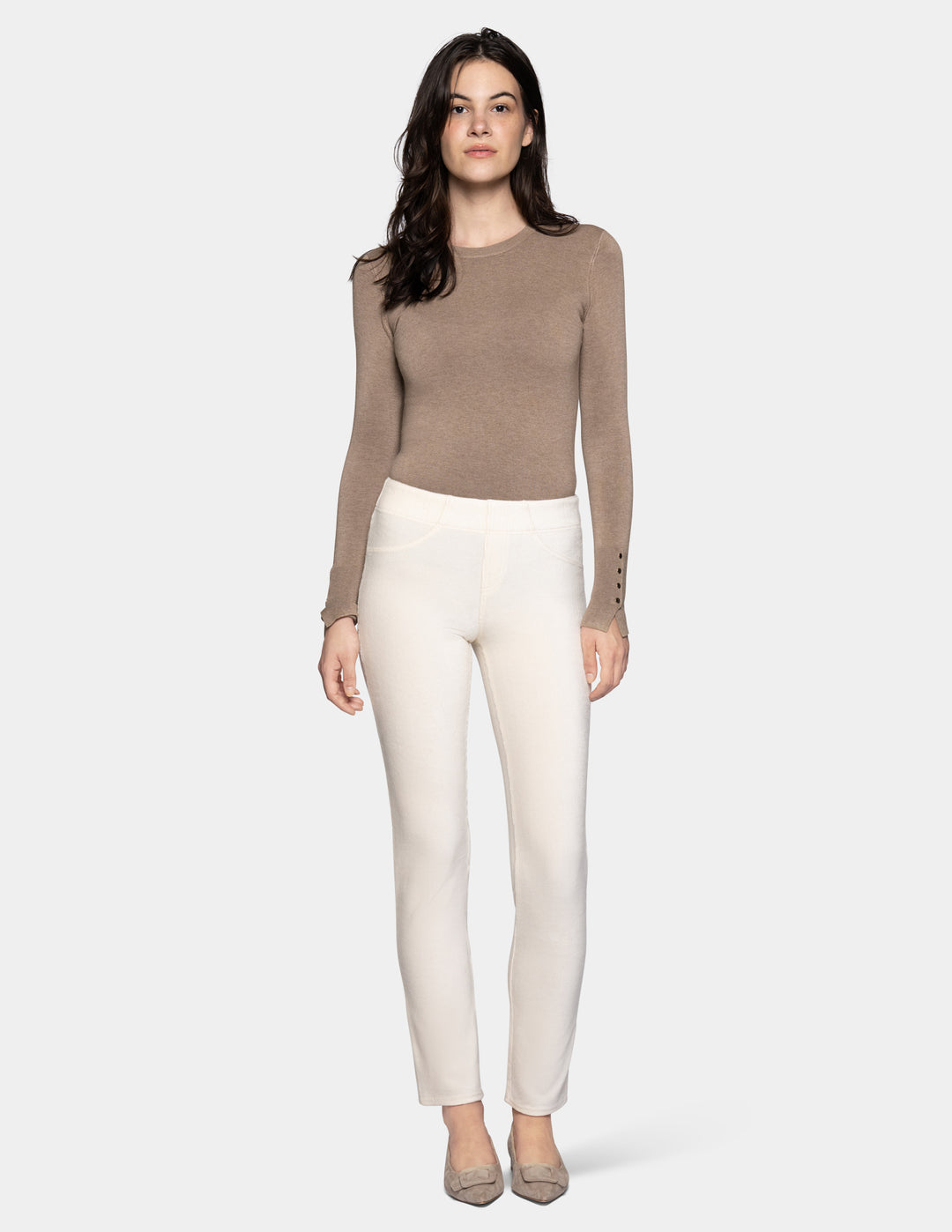 A model wearing off white corduroy pants with a long sleeve beige top and matching color shoes