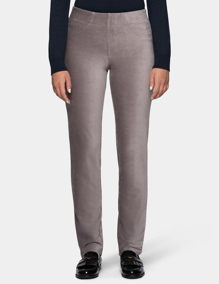 A model wearing grey corduroy pants from the waist down with a long sleeve black top and black shoes