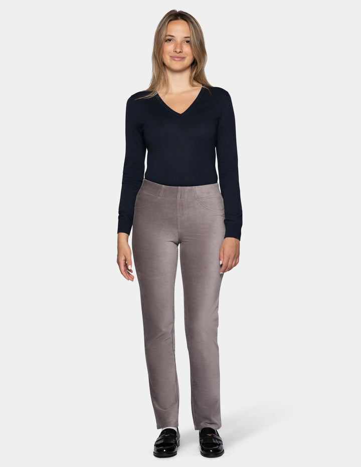 A model wearing grey corduroy pants with a long sleeve black top and black shoes