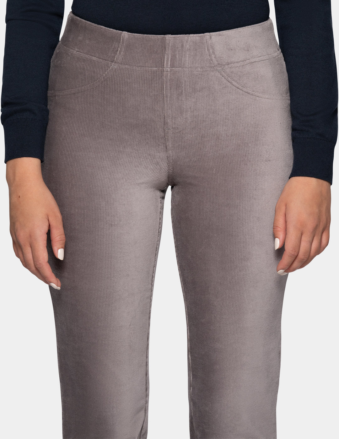 A close-up view of a model wearing grey corduroy pants with a long sleeve black top