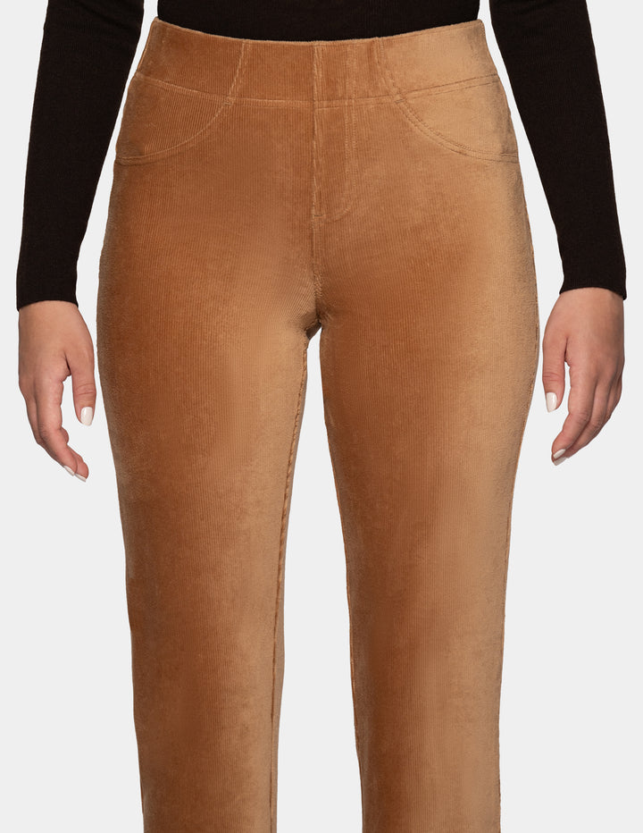A close-up view of a model wearing tan corduroy pants with a long sleeve black top