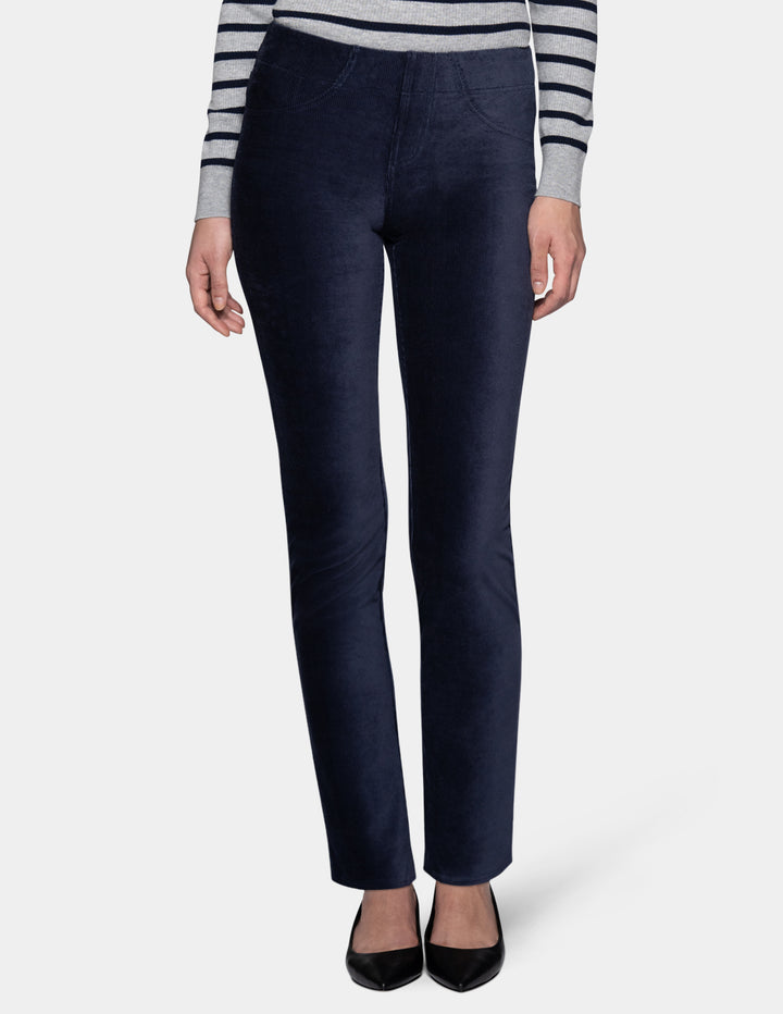 A model wearing navy corduroy pants with a long sleeve stripe shirt and pointed toe shoes