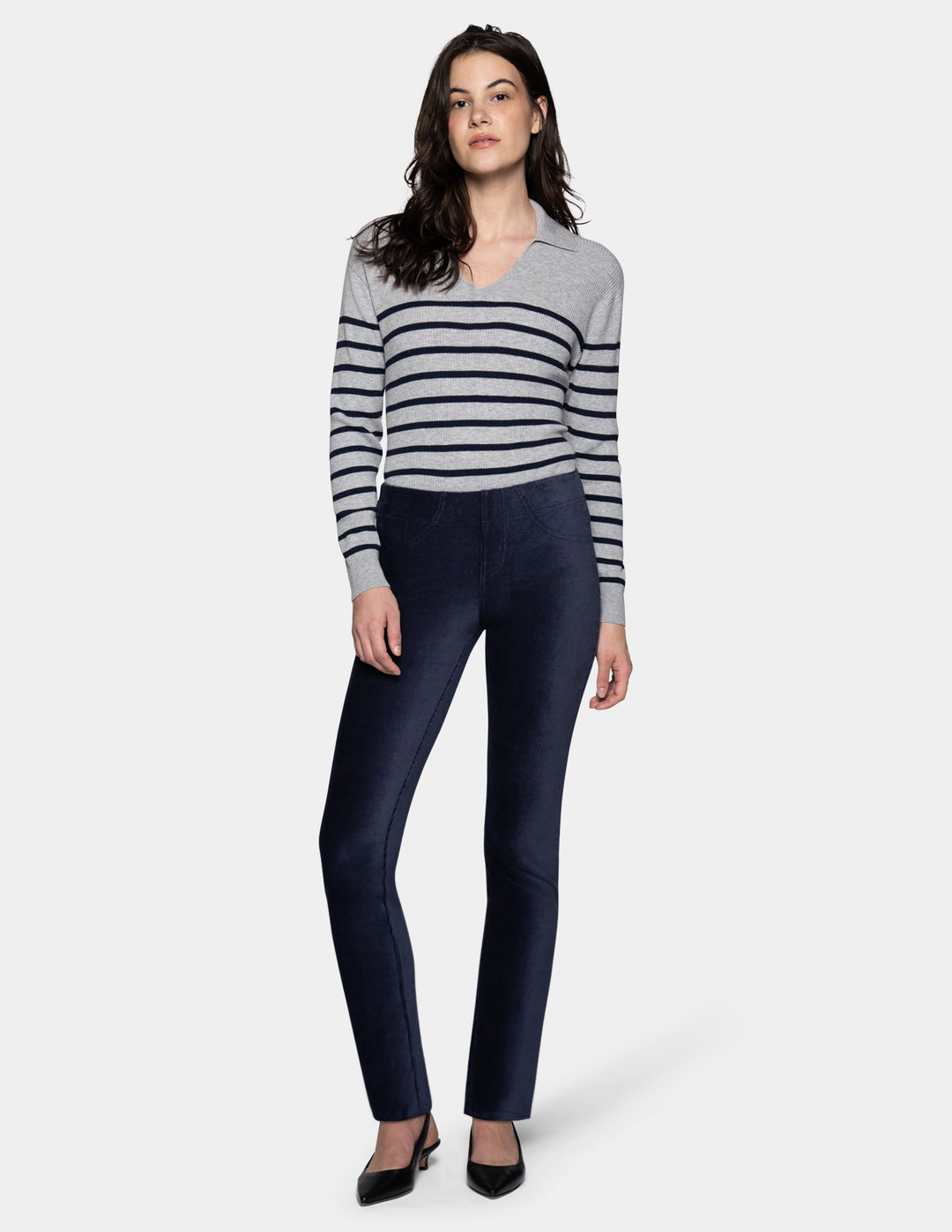 A model wearing navy corduroy pants with a long sleeve stripe shirt and pointed toe kitten heels
