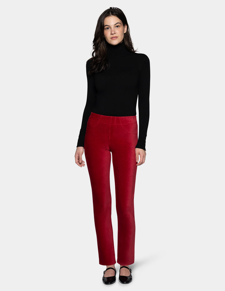 A model wearing red corduroy pants with a long sleeve black top and black shoes