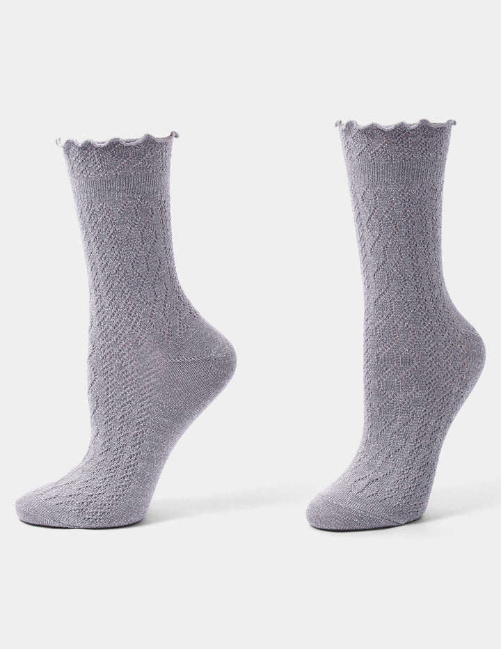 Grey crew socks with a ruffled edge photographed against a light gray background.