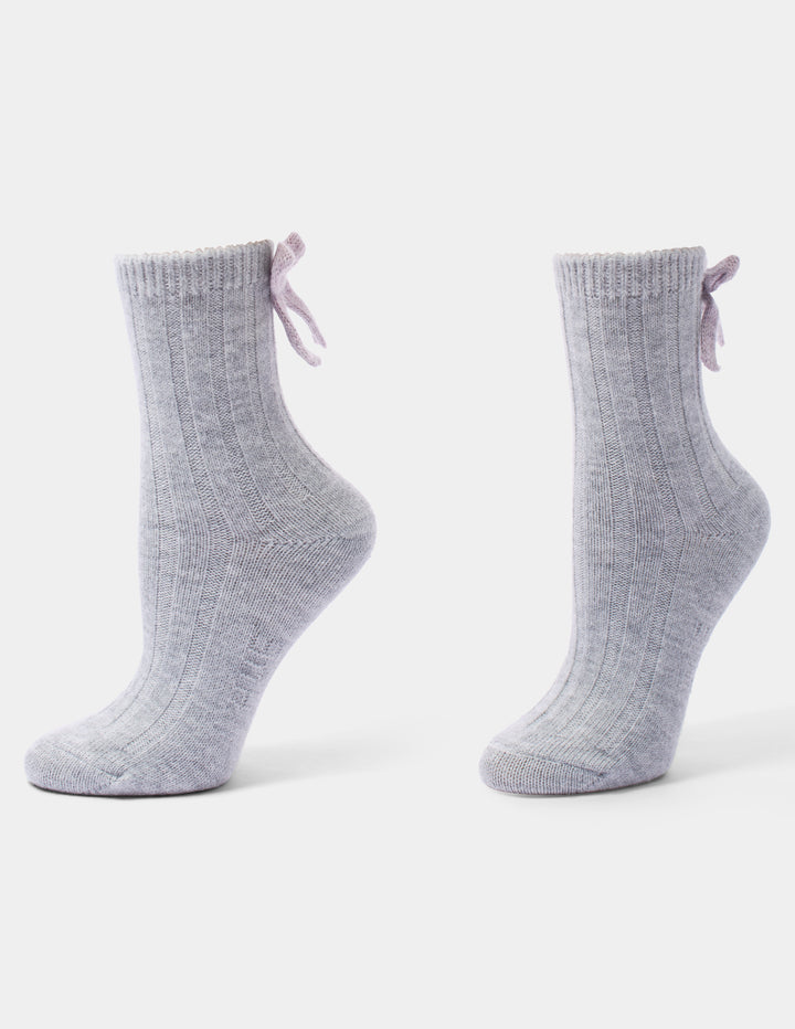 A pair of light grey anklet socks with a pink bow accent, displayed against a light gray background.