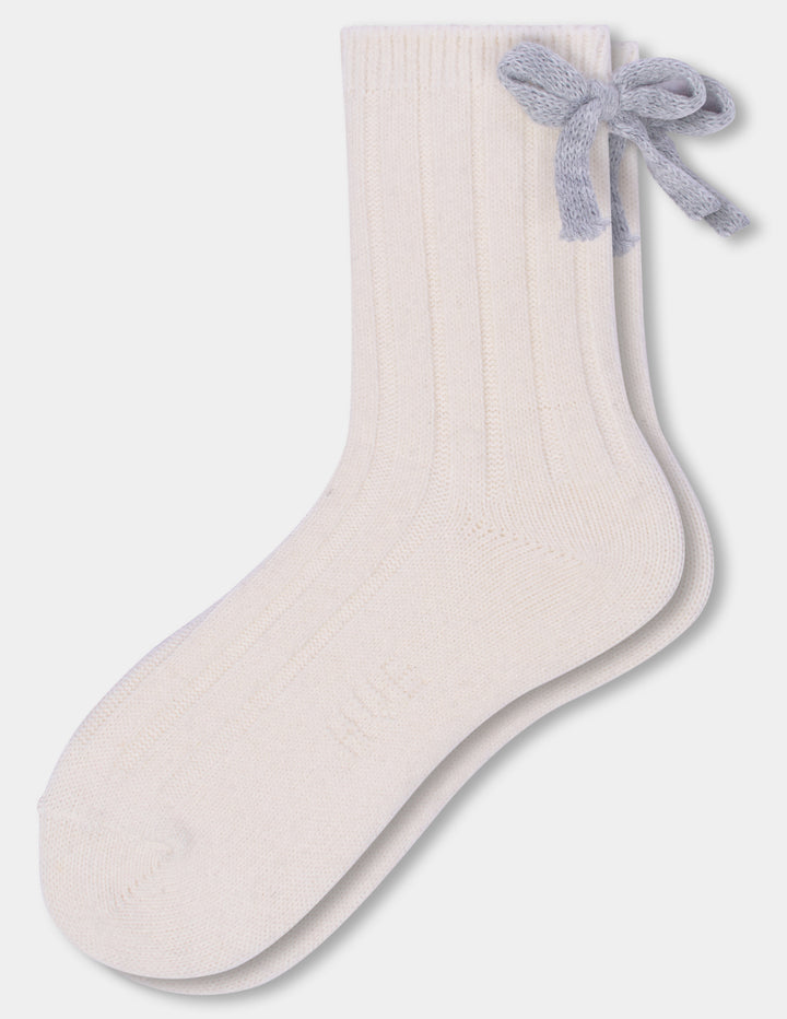 An ivory anklet sock with a grey bow accent photographed against a light gray background.