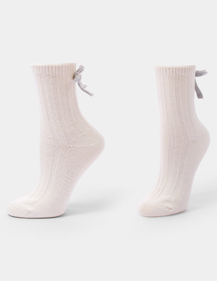 An ivory anklet sock with a grey bow accent photographed against a light gray background.