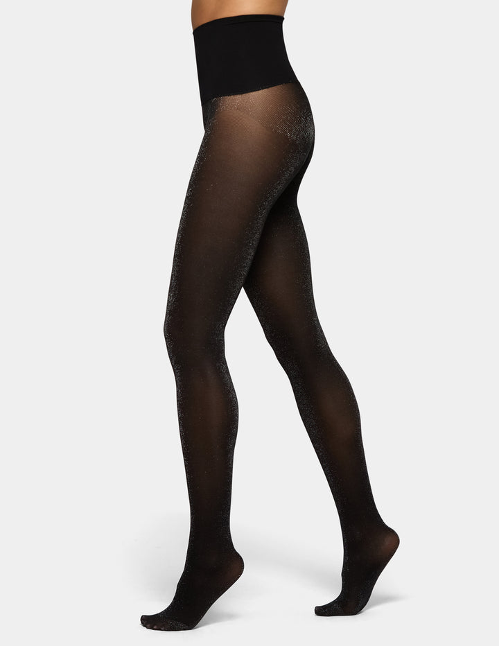 A model wearing black lurex yoga tights.