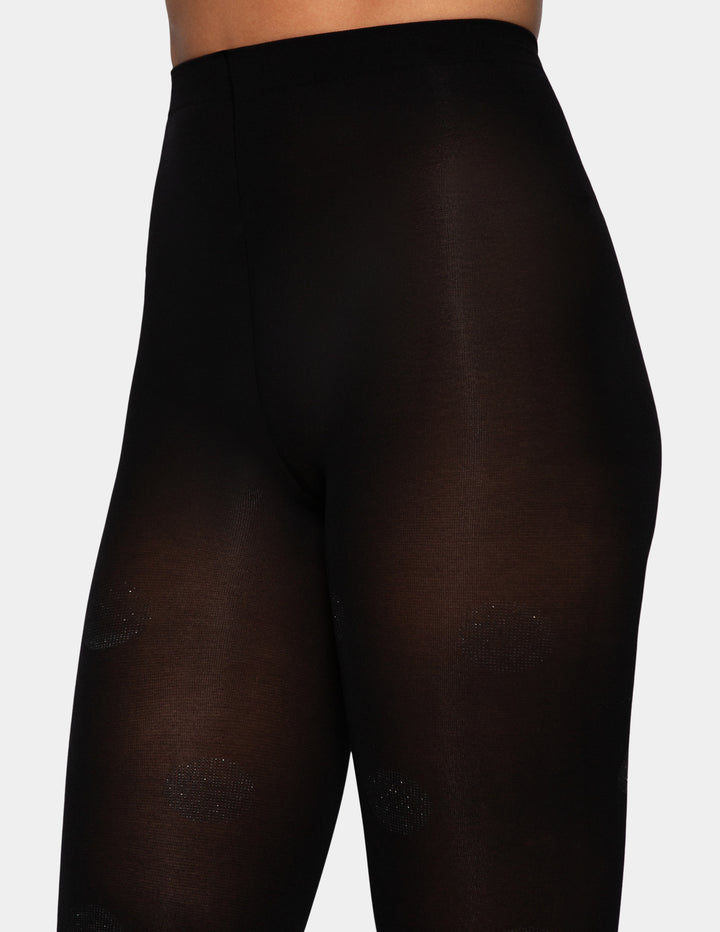 A model wearing black tights with polka dot designs.