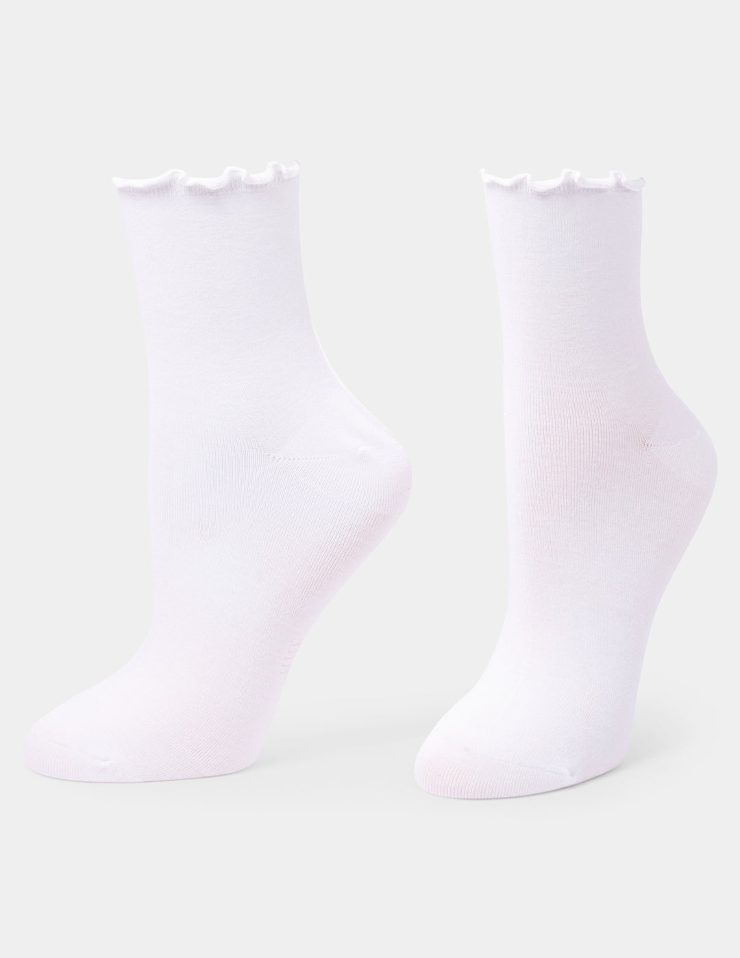 A pair of white crew socks with a ruffled trim at the top, displayed on foot forms against a light gray background.