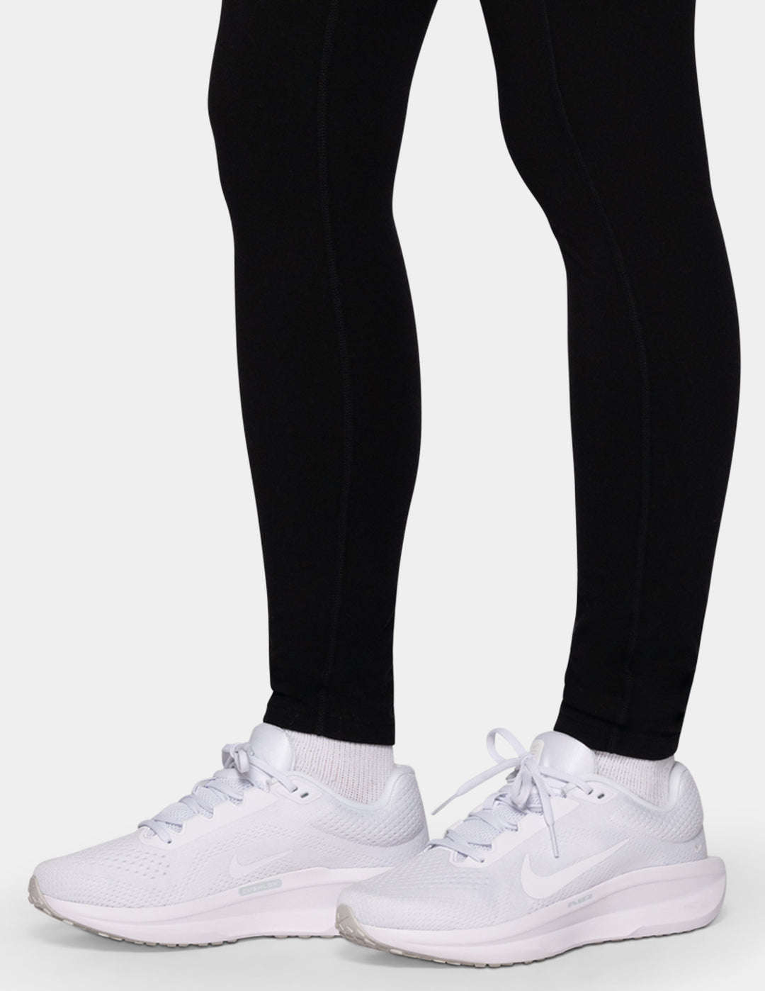 A model wearing black leggings and white sneakers.