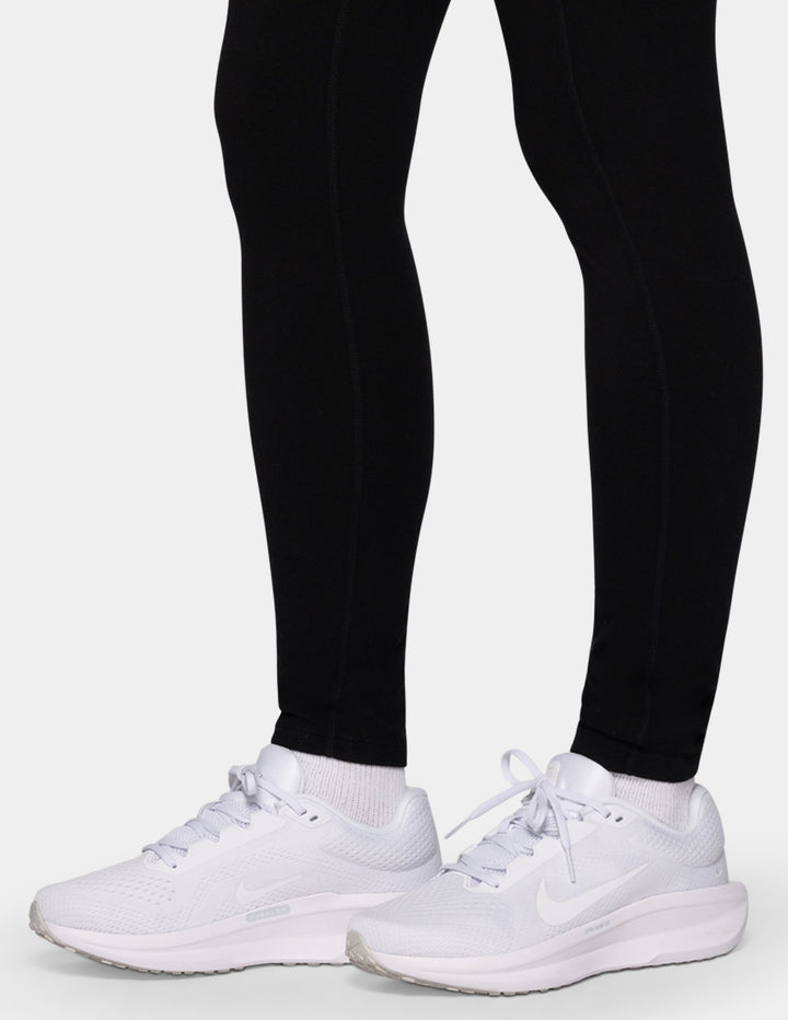 A model wearing black leggings and white sneakers.