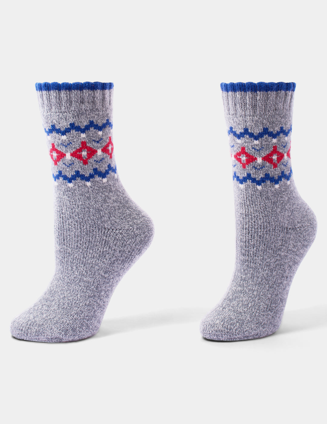 A pair of grey, blue, and red holiday pattern crew socks with little white accents displayed against a light grey background.