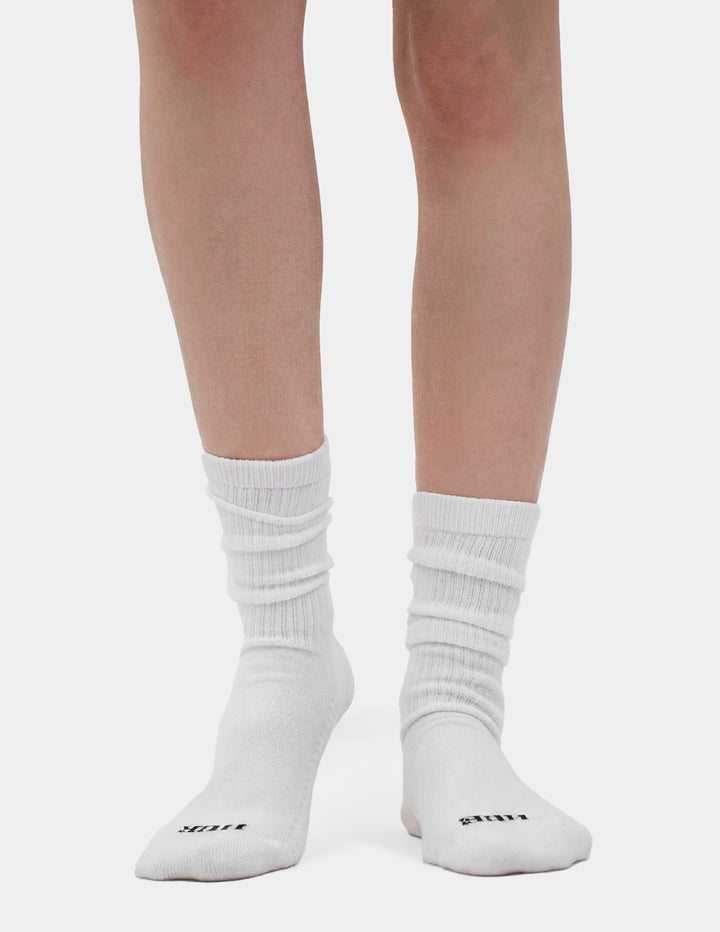White socks with HUE brand logo worn by a person on a light gray background
