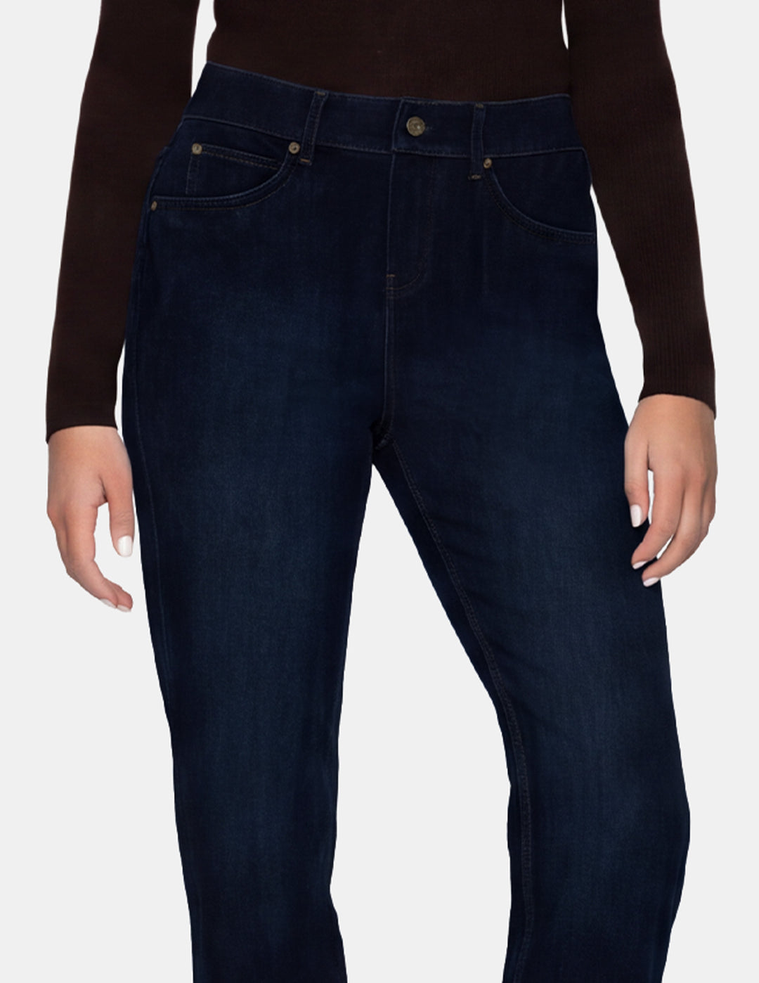 A model wearing dark blue denim pants and a long sleeve brown top photographed against a light gray background.