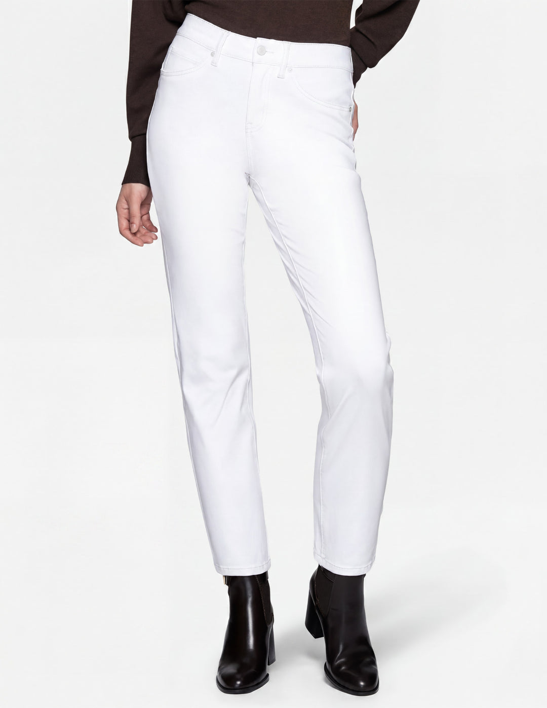 A model wearing white pants, a long sleeve top, and black boots photographed against a light gray background.