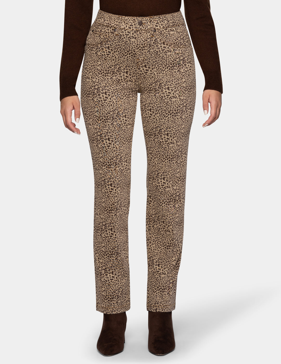 A model wearing cheetah pants, a long sleeve brown top, and brown boots photographed against a light gray background.