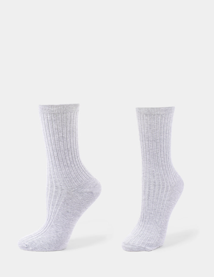 A light grey pair of ribbed crew socks displayed against a light gray background.